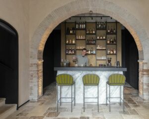Area reception con bar in pietra scolpita e rame ossidato, ristorante in Val d’Orcia di Foster + Partners