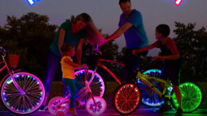 Famiglia in bici con luci LED colorate su ruote